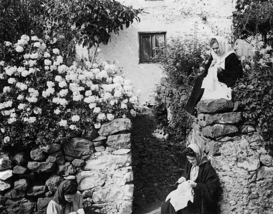 Retrato de um grupo de bordadeiras madeirenses junto a uma habitação 