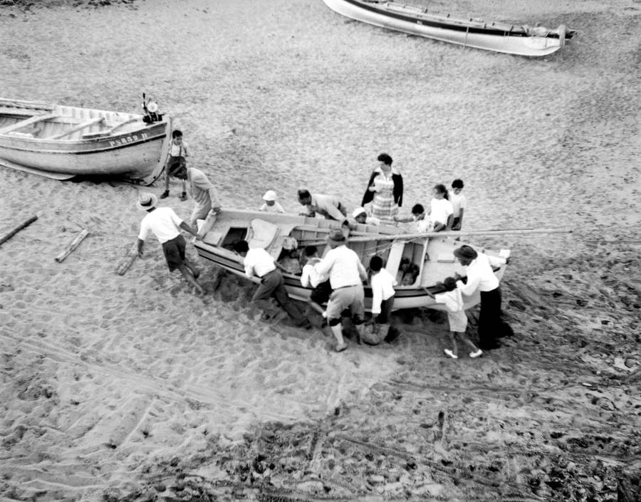Grupo de homens a varar um barco de pesca