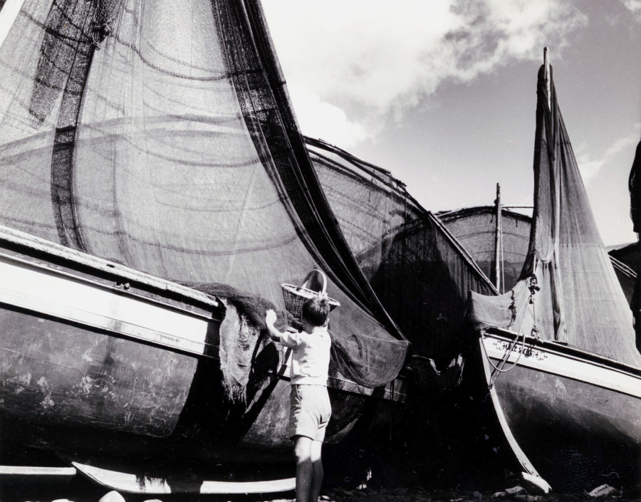 Criança junto de embarcações varadas na baía de Câmara de Lobos | 1971 